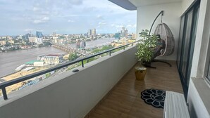 En balkong med utsikt över stadsbilden, en hängstol och ett element.