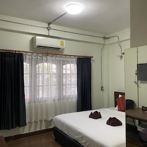 A hotel room with a bed, a desk, and an air conditioning unit. - Huenphen House And Cafe' (Chiang Mai)