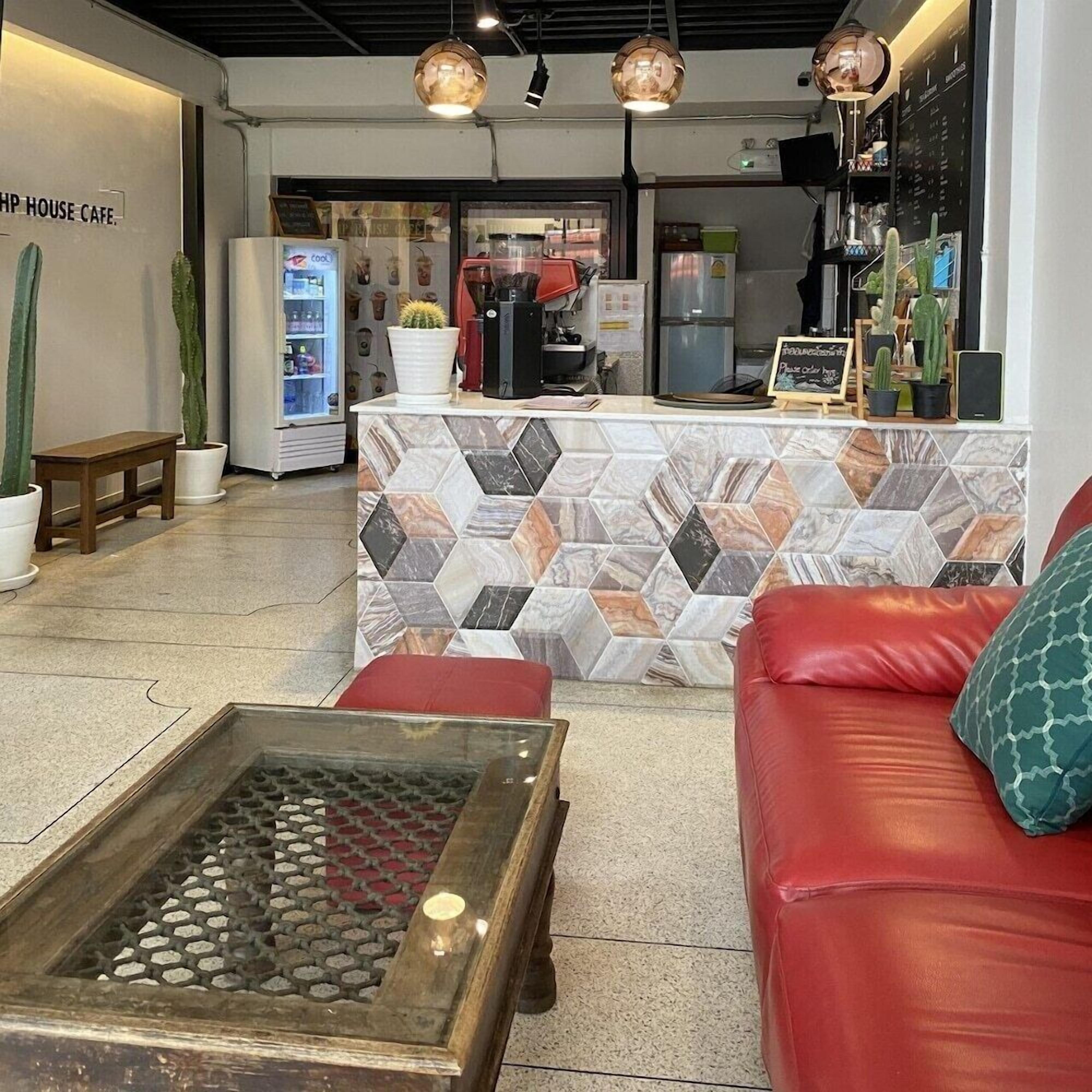 Un interior de cafetería moderno con mostrador, zona de estar y nevera.