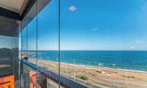 A coastal road with a beach, a clear sky, and a view of the ocean. - Studios in Building w/ Pool and Gym - Jdns (Salvador)