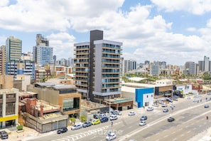 A cityscape with modern buildings, a busy street, and a clear sky.
