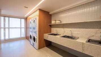 A modern kitchen with built-in appliances, a granite countertop, and a large window.