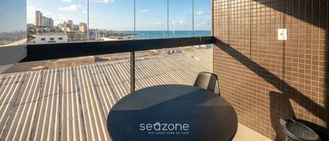 Una habitación moderna con un ventanal grande que da a una vista de la ciudad y el mar.