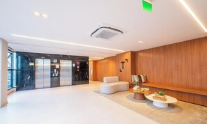 A modern lobby with a reception desk, seating area, and elevators. - Studios in Building w/ Pool and Gym - Jdns (Salvador)
