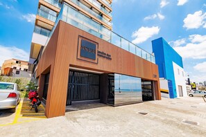 A modern building with a sign reading 'HOUSE' and a large glass entrance. - Studios in Building w/ Pool and Gym - Jdns (Salvador)