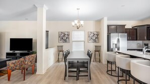 A modern kitchen with dark cabinets, a stainless steel refrigerator, and a white countertop. - Spacious 5-bedroom house access to Gym and two Pools (Greensboro)