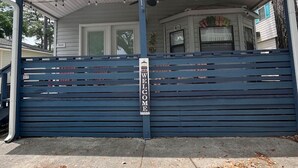 Een huis met een overdekte veranda, een Amerikaanse vlag en een 'WELCOME'-bord.