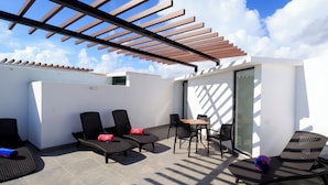 A rooftop patio with lounge chairs, a table, and a pergola. - Penthouse con Jacuzzi Privado en Tulum (Tulum)