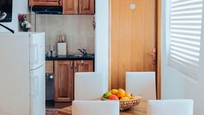 Una cuina amb armaris de fusta, un rentaplat i una safata de fruita al taulell.