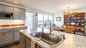 A kitchen with a large sink, cabinets, a microwave, and a view through the door. - OCEANFRONT New Custom Built 3Bdrm Handicap Accessible Home VIEWS & BEACH ACCESS (Jonesport)