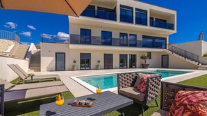 A modern two-story house with a swimming pool, outdoor seating, and a staircase. - Luxury apartment LaRiv II with pool (Krk)