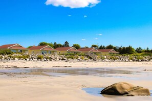 A beachfront property with multiple houses, a sandy beach, and a rocky shoreline. - Oceanfront 2-Bedroom Cottage | King Bed | Pet-Friendly Getaway (Lockeport)