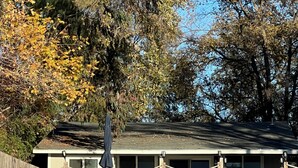 A building with a covered patio area, a fenced swimming pool, and a staircase leading to a deck. - Peaceful Lakeside Retreat - Cozy 3BR Waterfront Home - Secure Parking (Clearlake)