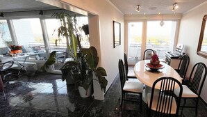A dining area with a round table, chairs, and a potted plant. - Fully furnished apartment with panoramic views of Cologne (Bergisch Gladbach)