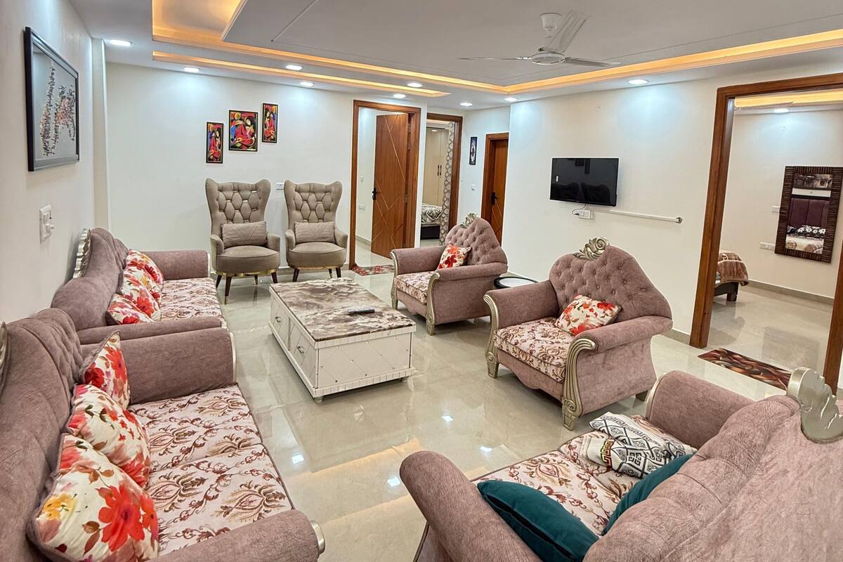 A modern living room with sofas, armchairs, a coffee table, and a television.