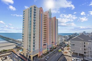 A multi-story hotel with balconies, located near a beach and a pier. - Prince Resort at Cherry Grove Pier with lazy river (North Myrtle Beach)