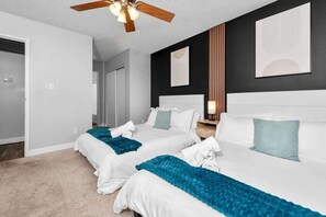 A hotel room with two beds, a ceiling fan, and artwork on the walls. - Bright 2BR Near ASU, Pool, Grill, Prking (Tempe)