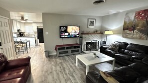 A living room with a TV, a fireplace, a couch, and a coffee table. - 3/1 Clean and comfortable home in Fair Oaks (Fair Oaks)
