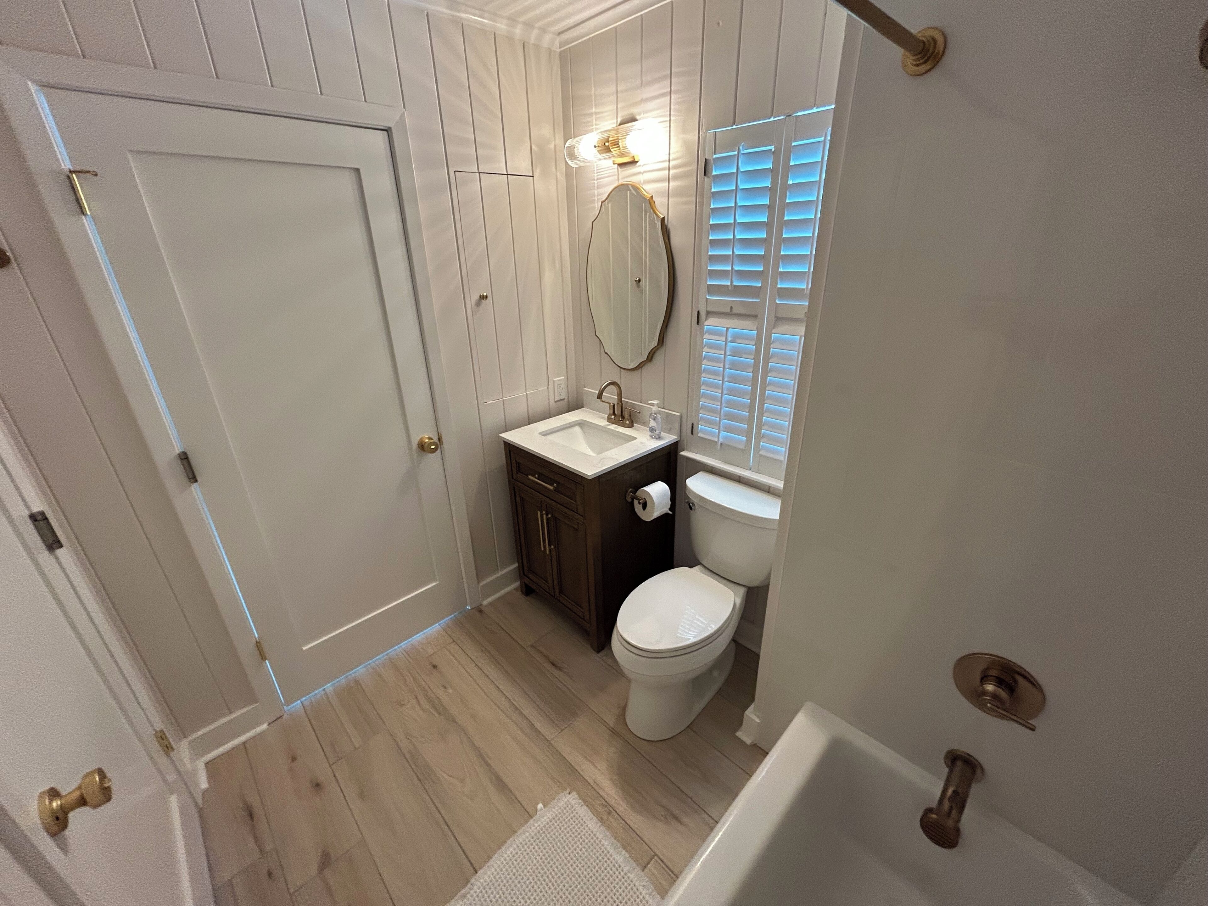 A bathroom with a white toilet, a sink, and a mirror.