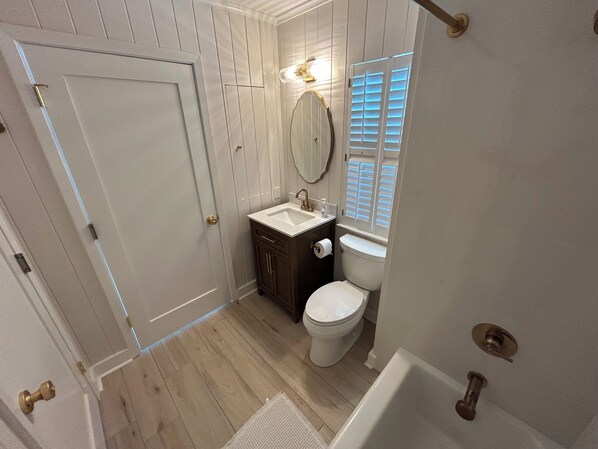 A bathroom with a white toilet, a sink, and a mirror.