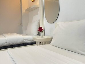 A hotel room with a neatly made bed, a small round table with a vase of red roses, and a large mirror on the wall. - Shan Boutique Hotel (Chiang Mai)