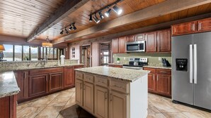A spacious kitchen with wooden cabinets, granite countertops, and stainless steel appliances.