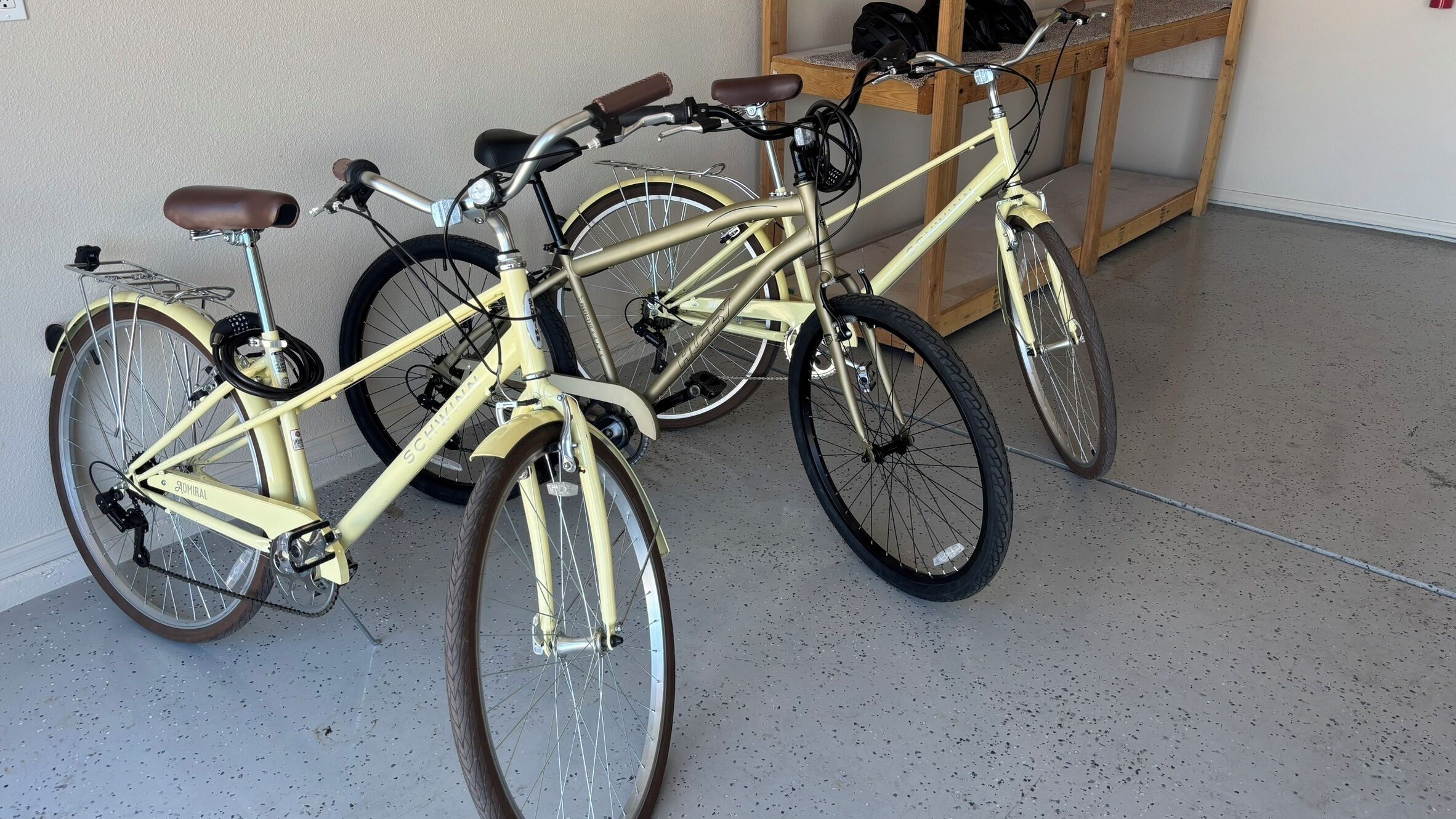 Una bicicleta con estructura color crema y asiento negro apoyada en una pared.