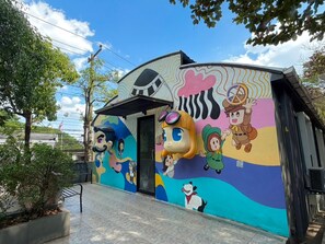 A colorful mural with cartoon characters and a building entrance. - BB House Chaingmai (Chiang Mai)