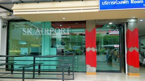 A hotel entrance with a sign reading "SKAIRPORT" and a blue sign above stating "Room for Rent". - S K Airport (Chiang Mai)