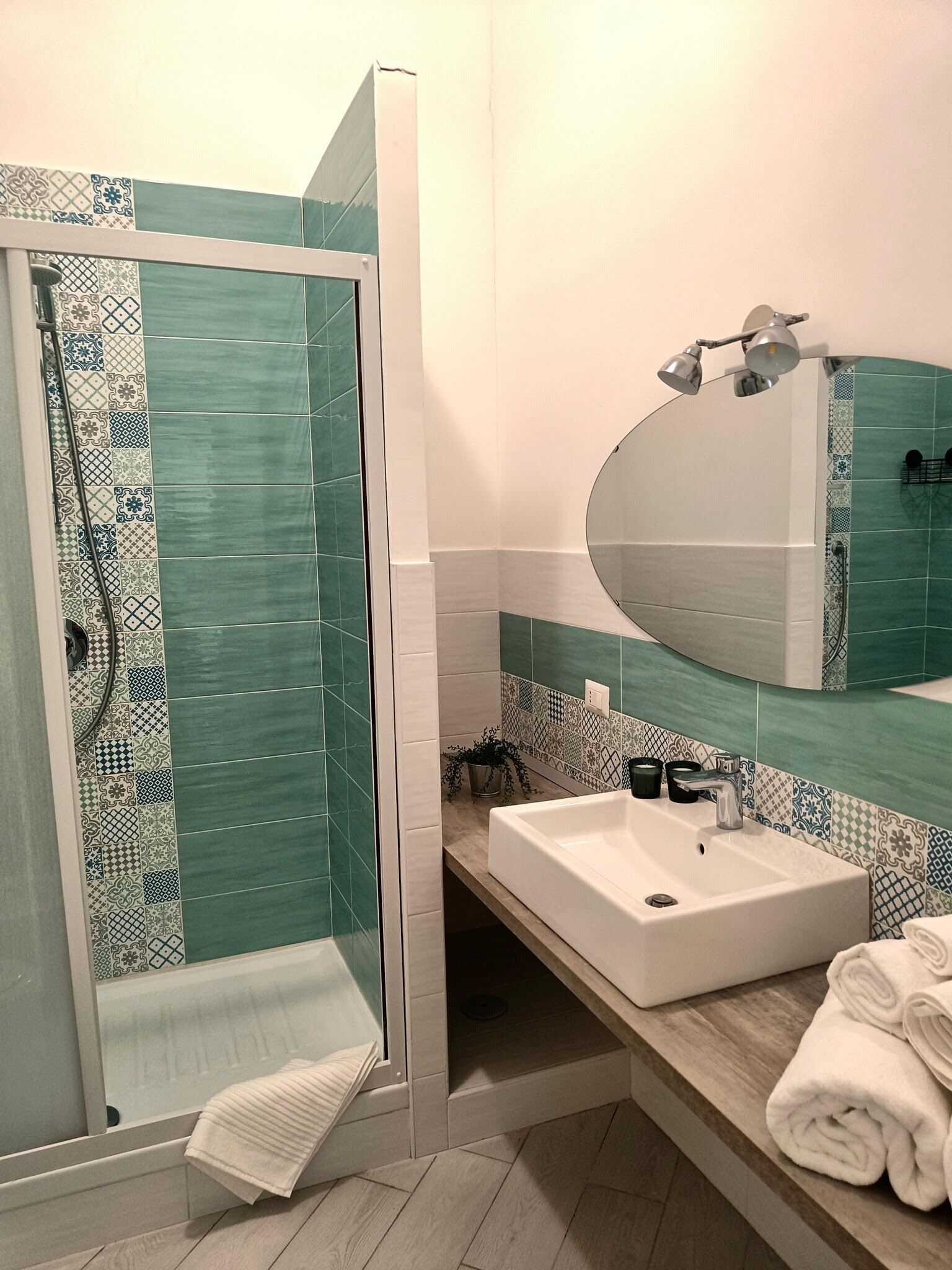 Ein Badezimmer mit Dusche, Waschbecken, Spiegel und Handtuch.