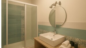 A bathroom with a shower, a sink, a mirror, and a towel. - Pansini Ruggiero's Apartaments (Naples)