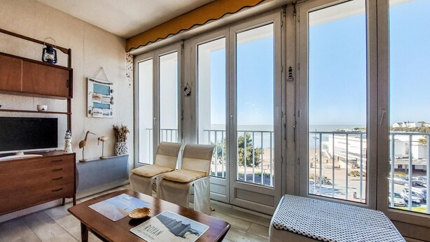 Une chambre dotée d’un balcon, d’une télévision, d’un bureau et d’une chaise.