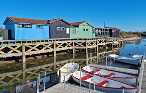 En träbrygga med färgglada hus och båtar som ligger förtöjda.
