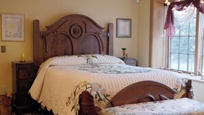 Un dormitorio con una cama grande, cabecera de madera y una ventana con cortinas.