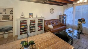 Ein Wohnzimmer mit einer braunen Ledersofa, einem Glastisch, einem Schuhschrank und einer Statue.