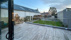 Ein Balkon mit Blick auf einen Garten und Gebäude.