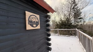 Een houten terras met een bord waarop staat 