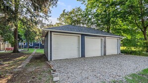A two-car garage with a gravel driveway and a covered patio area.