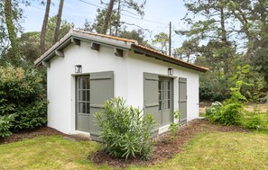 A small, single-story building with a sloped roof, two windows with shutters, and a door. - Villa d'exception bord de mer (Noirmoutier en l'île)