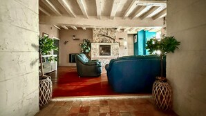 Una sala de estar acogedora con chimenea, asientos cómodos y plantas decorativas.