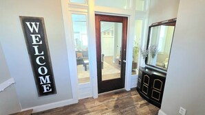 Un suelo de madera, un mueble negro con detalles dorados y un cartel que dice 'WELCOME' en la pared.