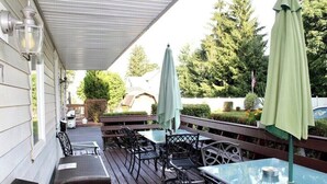 An outdoor patio with tables and chairs, umbrellas, and a covered area. - Baseball Property 3 Separate Homes Sleeps 20. Multiple Families & Teams Welcome. (Oneonta)