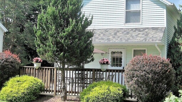A two-story house with a front porch, a small window, and a picket fence. - Baseball Property 3 Separate Homes Sleeps 20. Multiple Families & Teams Welcome. (Oneonta)
