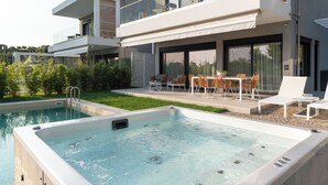 Una casa moderna con piscina e area salotto all'aperto.