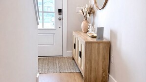 Ein Flur mit einem Holzschrank, einem Spiegel und zwei Teppichen.