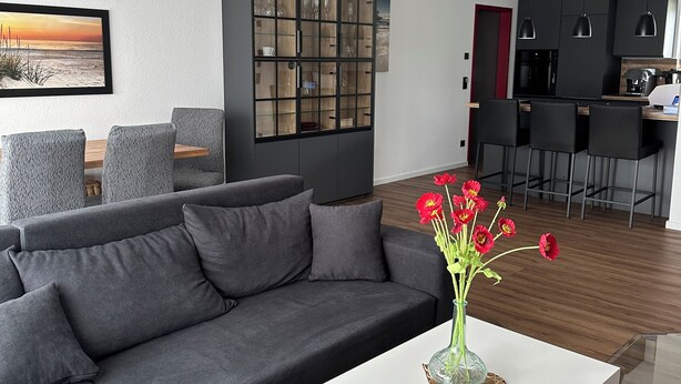 A modern living room with a sectional sofa, a white coffee table, and a glass cabinet. - Special accommodation with its very own style, modern and lovingly furnished, (Samtens)