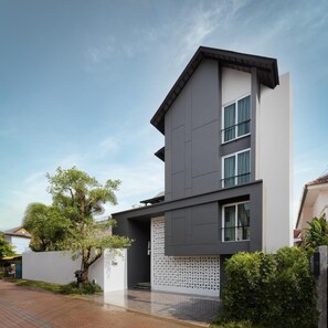 A modern two-story building with a flat roof, large windows, and a gated entrance. - Kiri Hotel Chiang Mai (Chiang Mai)