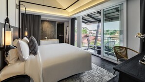 A modern hotel room with a large bed, a desk, a chair, a ceiling fan, and a balcony with a view. - Kiri Hotel Chiang Mai (Chiang Mai)