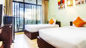 A hotel room with two beds, a balcony, a desk, and a TV. - B2 Khamtieng Boutique Budget Hotel (Chiang Mai)