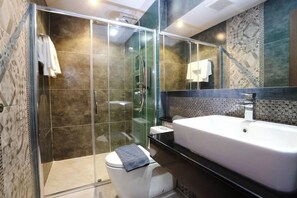 A modern bathroom with a glass-enclosed shower, a white toilet, and a large bathtub. - Marigold Lanna Boutique Hotel (Chiang Mai)